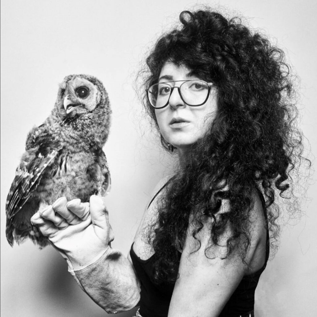 Sheida Soleimani looking at camera with an owl on her hand